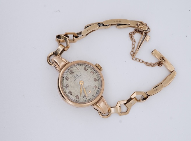 A lady's 9ct gold Record manual wind wrist watch, with Arabic dial and subsidiary seconds, on a 9ct gold bracelet, gross weight 16 grams. Condition - fair